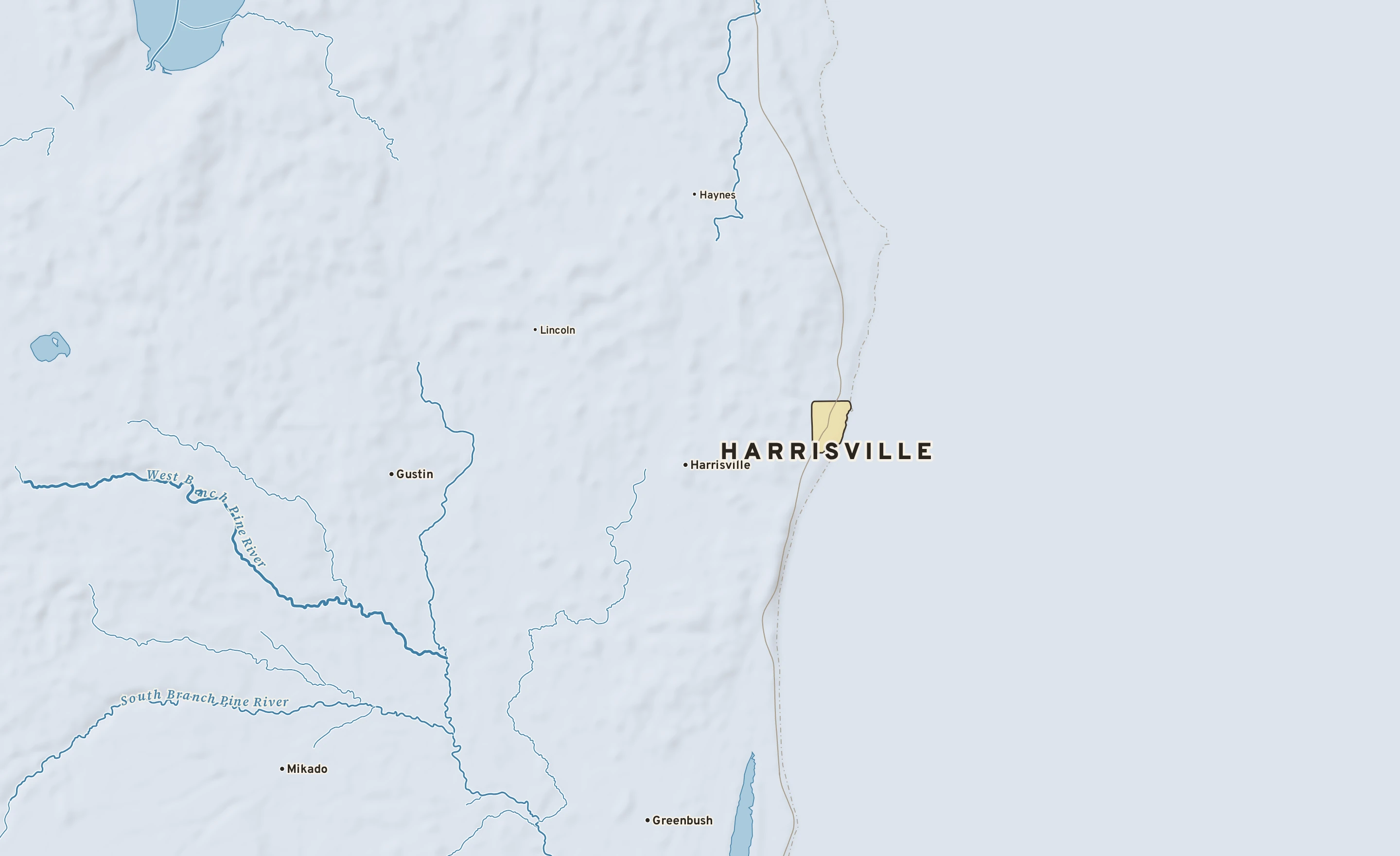 Shaded-relief atlas plate of Harrisville, Michigan: rivers, roads, the city limits and where the water drains.