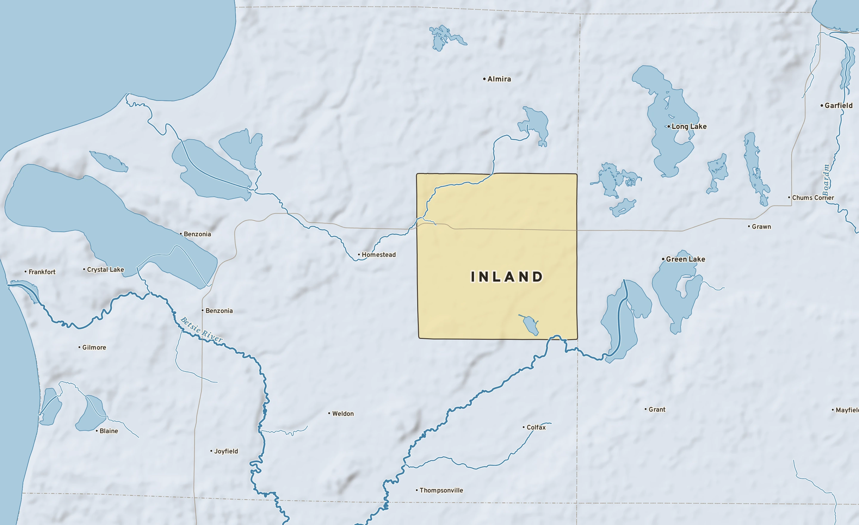 Shaded-relief atlas plate of Inland, Michigan: rivers, roads, the city limits and where the water drains.
