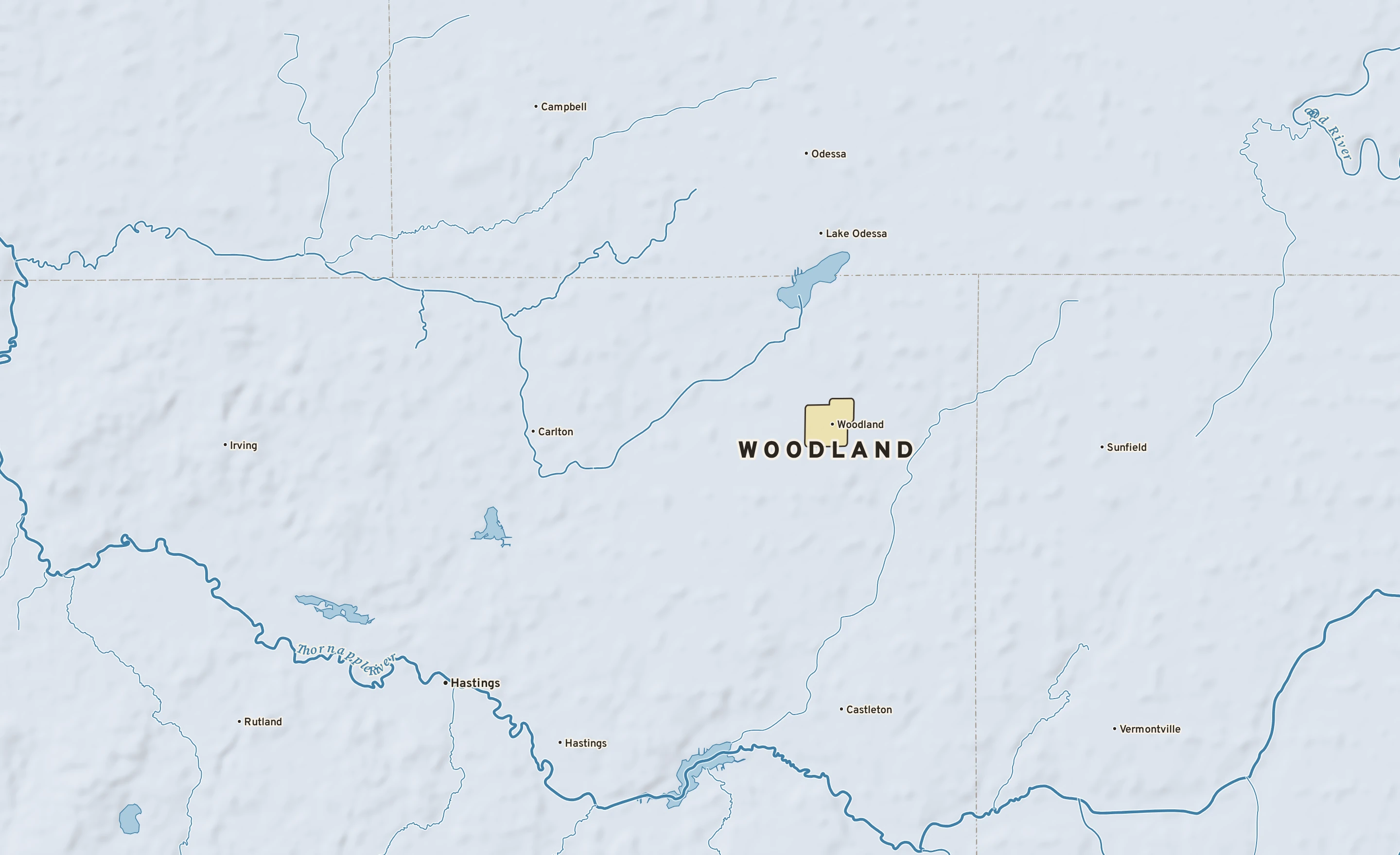 Shaded-relief atlas plate of Woodland, Michigan: rivers, roads, the city limits and where the water drains.